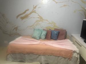 a bed with pillows on it in a room at Hotel Pousada Irmaos Freyhardt in Rio de Janeiro