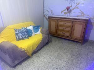 a bedroom with a bed with yellow sheets and a dresser at Hotel Pousada Irmaos Freyhardt in Rio de Janeiro