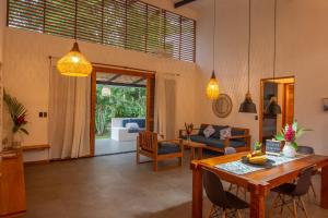 a living room with a wooden table and chairs at Tres Lodge Villa - Shared Pool - Natural Setting in Cocles
