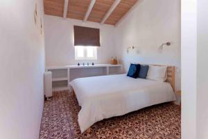 a bedroom with a large white bed and a window at Monte das Oliveiras - Casas de Campo in Estremoz +121 photos