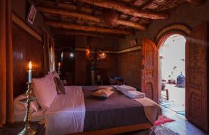 ein Schlafzimmer mit einem Bett und einer offenen Tür in der Unterkunft Kasbah Tebi in Aït-Ben-Haddou