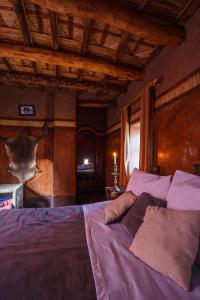 a bedroom with a large bed with purple sheets at Kasbah Tebi in Aït Ben Haddou