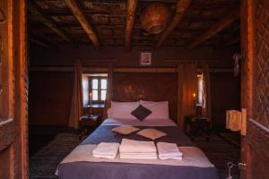 a bedroom with a bed with towels on it at Kasbah Tebi in Aït Benhaddou