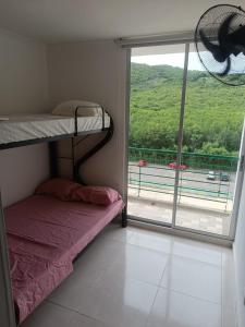 a bedroom with a bunk bed and a large window at Hermoso apartamento en Girardot in Girardot