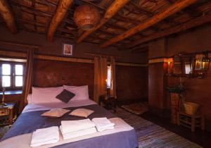 
a bedroom with a large bed and a large window at Kasbah Tebi in Aït Ben Haddou

