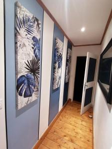 a hallway with three paintings on the wall at chambre d'hôte 50, rue Gambetta à Libourne in Libourne