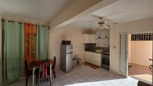 a kitchen with a refrigerator and a table and chairs at Wizzy Apartment White River in Ocho Rios