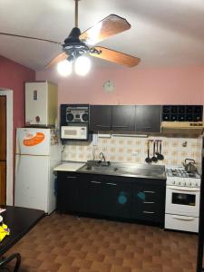 a kitchen with a white refrigerator and a ceiling fan at Hernandarias 2 in San Bernardo