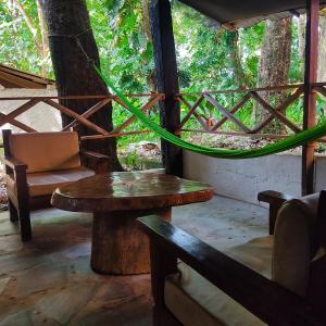 a room with a table and a chair and a tree at Hotel Caba&ntilde;as Safari in Palenque
