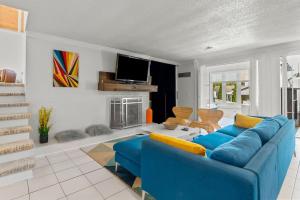 a living room with a blue couch and a tv at Modern Retreat Hot Tub Bar Patio HPU in High Point