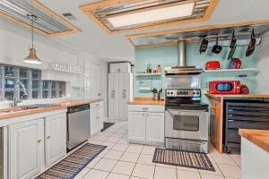 a large kitchen with white cabinets and appliances at Modern Retreat Hot Tub Bar Patio HPU in High Point