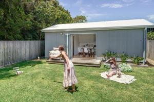two girls playing in the yard of a house at Moffat Beach Entertainer with Kids Retreat & Walk to Beach in Caloundra