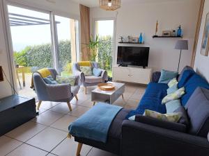 a living room with a blue couch and chairs at Villa in Crozon with Sea Views & Sandy Beach in Telgruc-sur-Mer