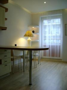 a table with a lamp in a room with a window at Apartament Super Poznań in Poznań