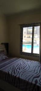 ein Schlafzimmer mit einem Zebra-Bett und einem Fenster in der Unterkunft Juliana Resort Pool VIP in Al Ḩammām