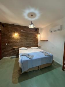 a bedroom with a bed in a room with a brick wall at Condomínio Aurora - Suítes in Jericoacoara +20 photos