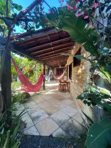 a patio with a hammock and a house at Condomínio Aurora - Suítes in Jericoacoara