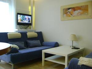 un salon avec un canapé bleu et une télévision dans l'établissement Apartament Super Poznań, à Poznań