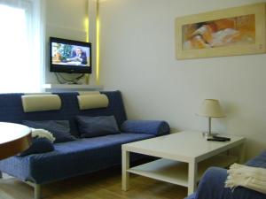 sala de estar con sofá azul y TV en Apartament Super Poznań, en Poznan