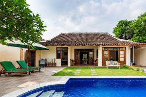 a villa with a swimming pool and a house at Villa Pondok Joglo in Yogyakarta