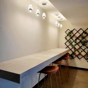 a kitchen with a large white counter and stools at Elegante apartamento cerca de Embajada de los EEUU y Cayala in Guatemala