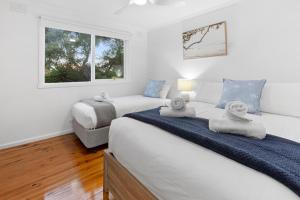 een witte slaapkamer met twee bedden en een raam bij A Vue De Rye in Rye +30 foto's