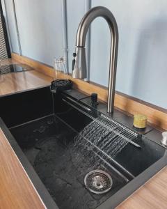 Un fregadero de cocina con agua saliendo de él en LoftenTequis, en Tequisquiapan
