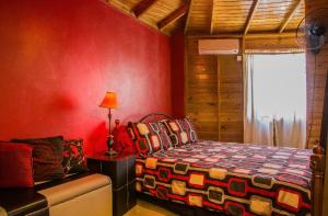 Un dormitorio con paredes rojas y una cama y un sofá. en One32 Guest House, en Kingston 18 fotos más