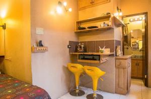 una cocina con 2 sillas amarillas en una habitación en One32 Guest House, en Kingston