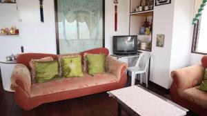 a living room with a couch and a tv at Mangrove Breeze Country Inn by RedDoorz in Del Carmen