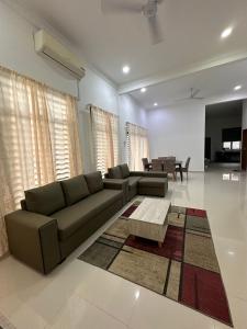a living room with a couch and a coffee table at Homestay Kemaman Fyna08 Semi-D, 4 Bedrooms Dekat Pantai Kijal in Kijal