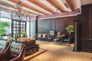 a lobby with a desk and a table with chairs at Alagon D'antique Boutique Hotel & Spa in Ho Chi Minh City