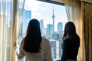 two women looking out a window at the city at Sheraton Centre Toronto Hotel in Toronto