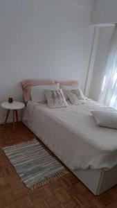 a bedroom with a white bed with pillows and a table at Departamento en San Isidro in Acassuso