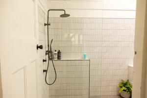 a shower in a bathroom with white tile walls at Mimosa Wines in Murrah