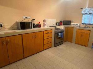 a kitchen with a microwave and a stove top oven at Casa Guadalupe Victoria in Matamoros