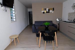 a living room with a table and chairs and a couch at LA DESIRADE SAINTE-ANNE in Sainte-Anne