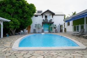 a swimming pool in front of a house at LA DESIRADE SAINTE-ANNE in Sainte-Anne
