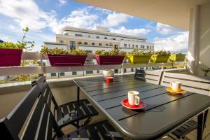 ein Tisch auf einem Balkon mit zwei Tassen Kaffee in der Unterkunft Appartement cosy aux portes de Disney in Chessy