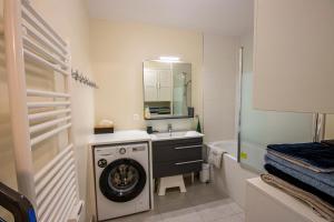 ein Badezimmer mit Waschmaschine und Waschbecken in der Unterkunft Appartement cosy aux portes de Disney in Chessy + 23 Fotos