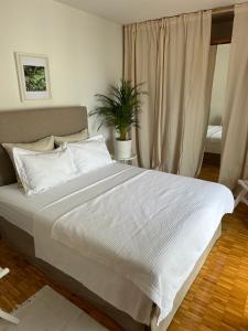 a bedroom with a large bed with white sheets at Apartmani Krk in Krk