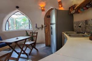 a kitchen with a table and a refrigerator at Casa Domo in Buenavista