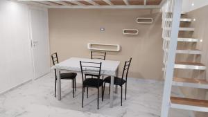 a dining room with a white table and black chairs at Proxima in Nola