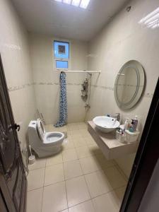 ein Badezimmer mit Toilette, Waschbecken und Spiegel in der Unterkunft Moonlight Resort in Sinādil