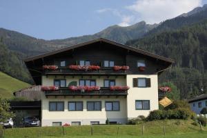 a building with flower boxes on the side of it at Pension Bergblick in Kaprun