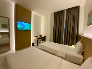 a hotel room with a bed and a desk at OPI Indah Hotel in Palembang