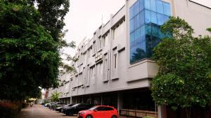 a red car parked in front of a building at OPI Indah Hotel in Palembang