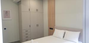 a bedroom with a bed and a white cabinet at SKIATHOS MODERNO in Skiathos +4 photos