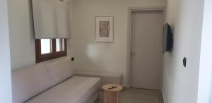 a white bathroom with a bench and a window at SKIATHOS MODERNO in Skiathos