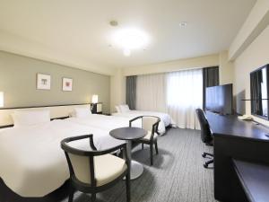 Una habitación de hotel con dos camas y un escritorio. en Richmond Hotel Nagoya Nayabashi, en Nagoya